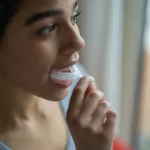Woman putting in an oral appliance for sleep apnea