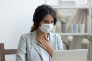woman sitting at a computer, not feeling well