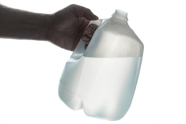 Hand holding a jug of distilled water
