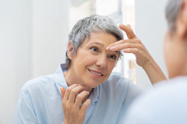 mature person checking skin for dermatitis